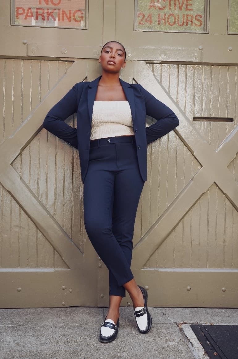 A woman relaxes in her navy suit before going to work.