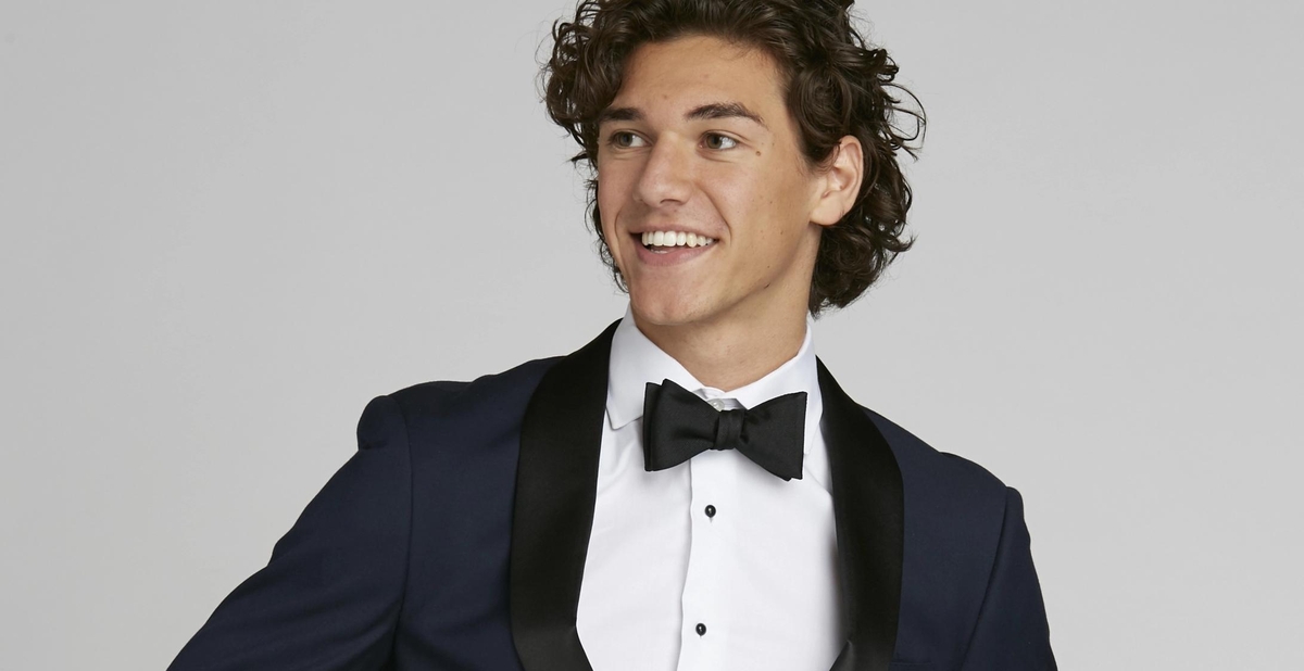 Navy blue prom tuxedo closeup with prom suit accessories like bow ties, tuxedo shirt, cufflinks, & suspenders.