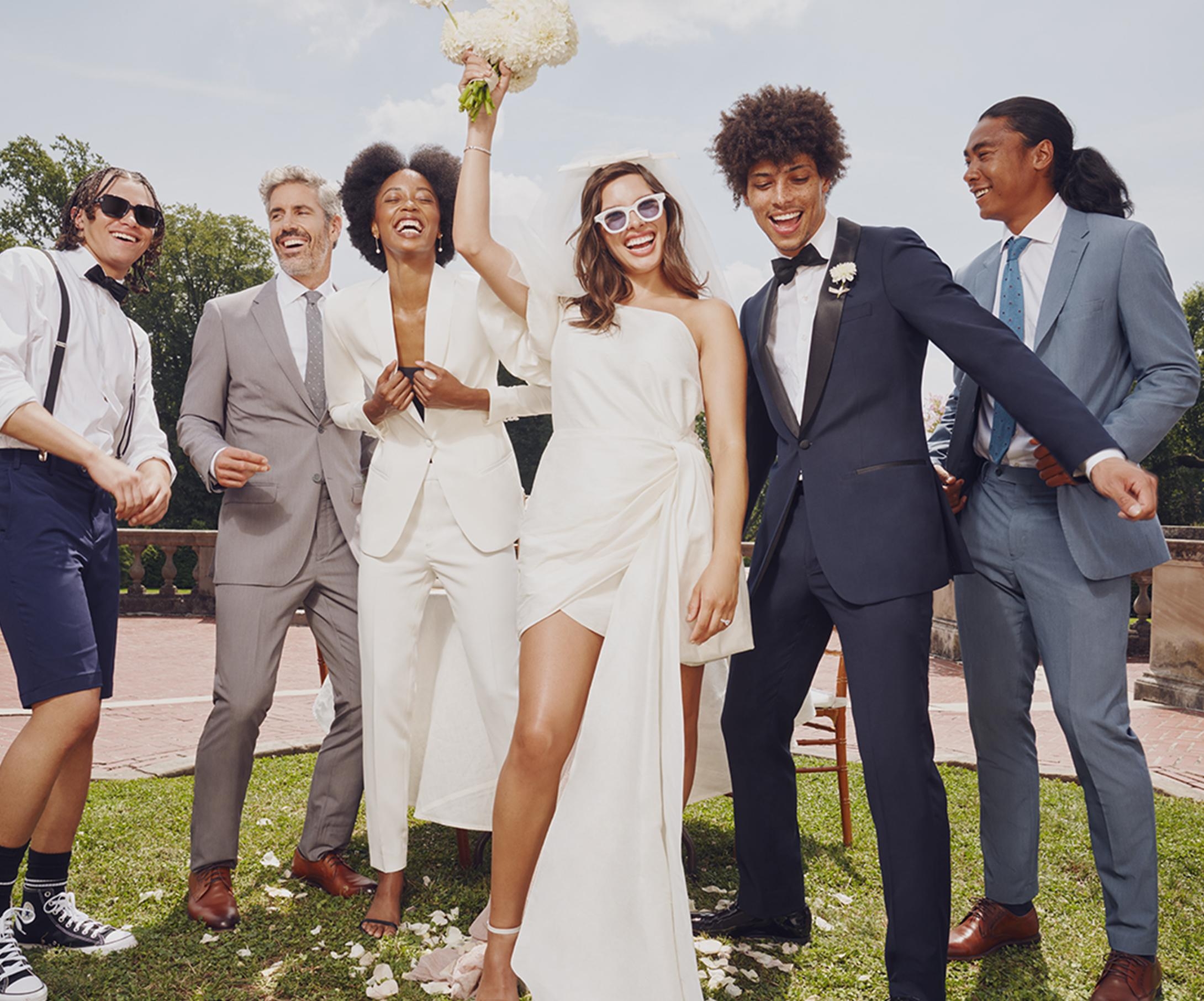 Mixed gender bridal party in black tie optional attire of stylish grey & blue wedding suits & tuxedos.