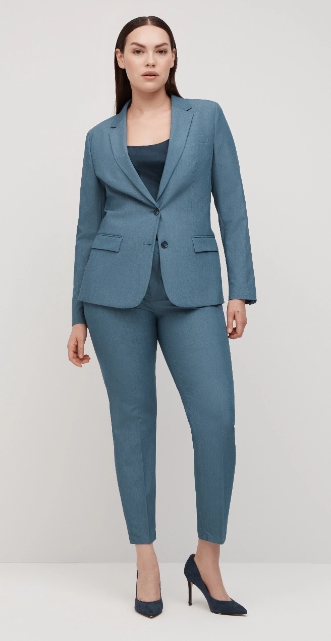 Average size women in flattering light blue women's suit jacket & well-fitted slim women's suit pants.