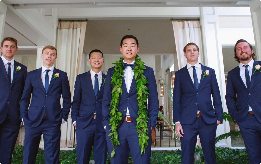 Groomsmen wearing perfect fit royal blue suits from virtual appointments posing with groom wearing Hawaiian lei.