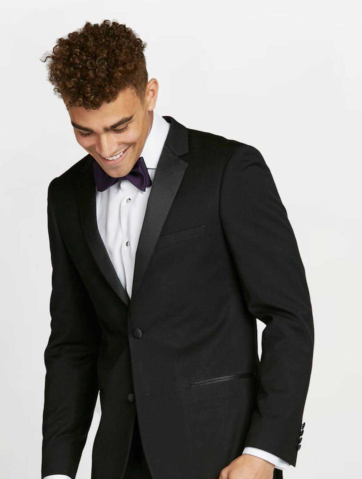 Candid prom picture of teen in black prom tuxedo, black prom bow tie & white tuxedo shirt.