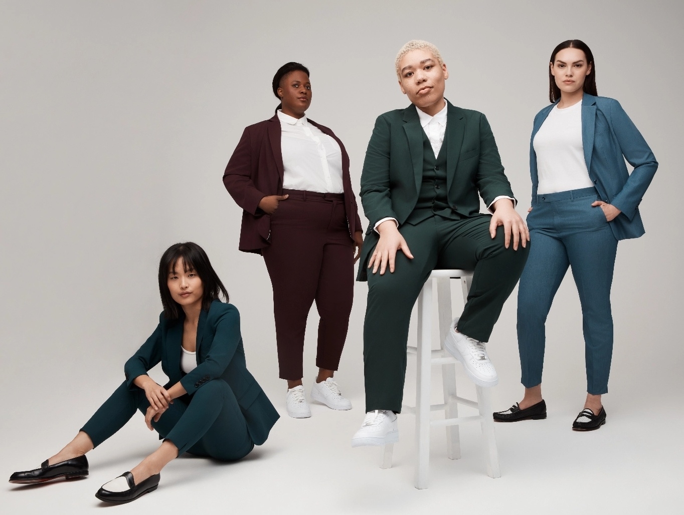 Petite, plus sized, nonbinary, and average size woman posing in women's suits and unisex suits.