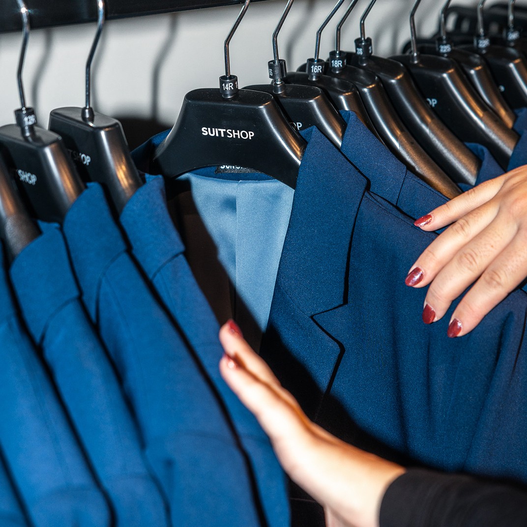 Browsing SuitShop's royal blue suits in Columbus suit store showroom.