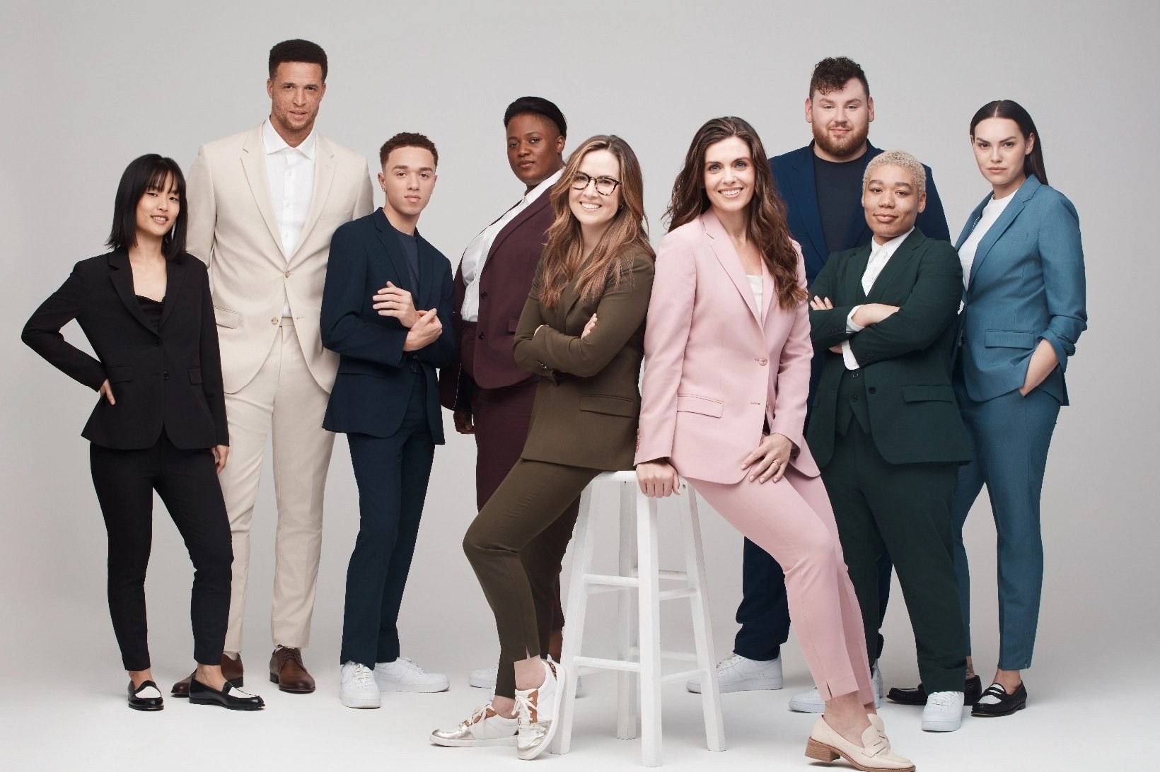 Men, women, and nonbinary models in exciting suit colors like mauve, light pink, and olive suits for petite and plus size suits.